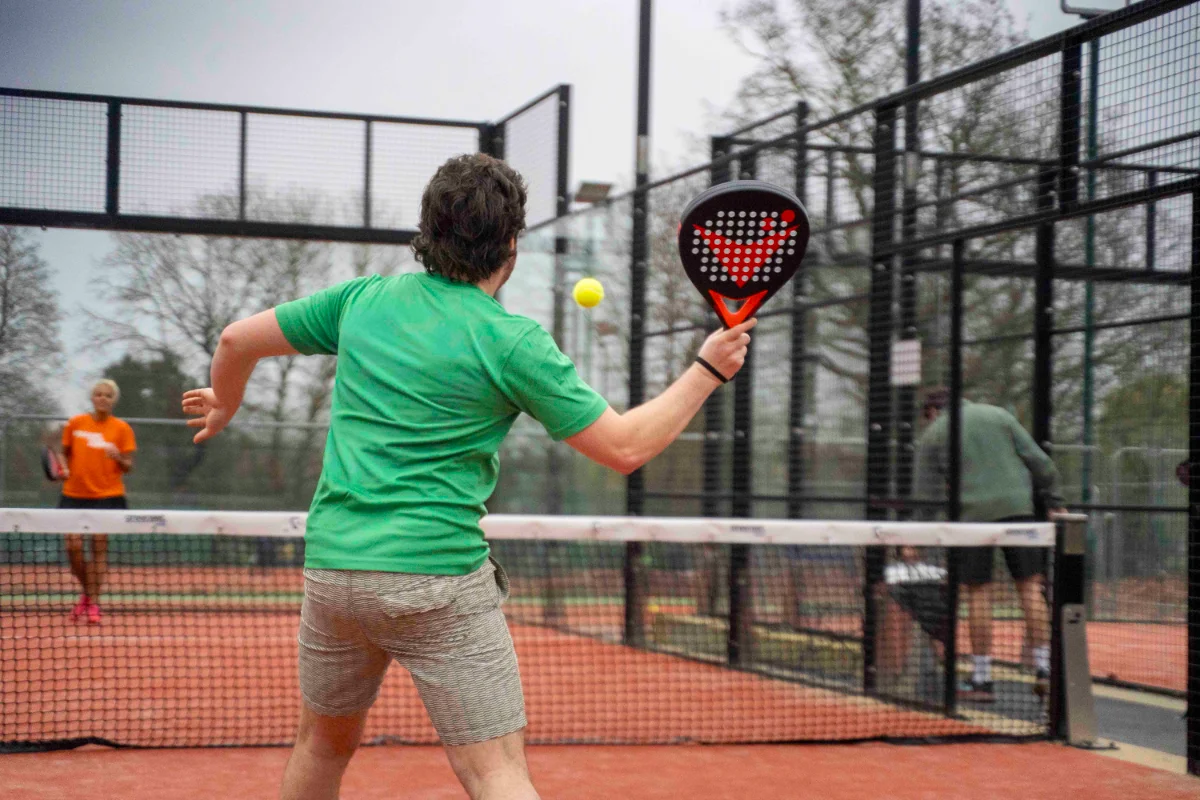 Man hitting a padel shot with Vadetep padel racket on outdoor court