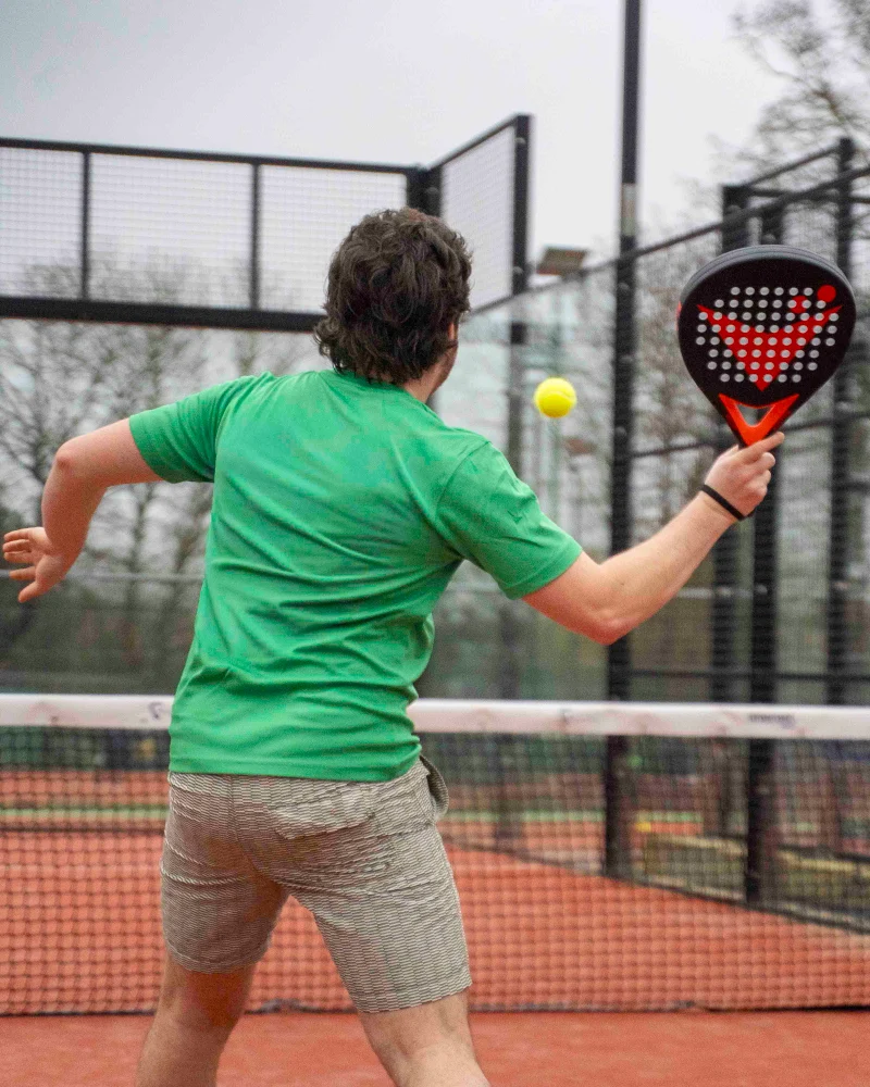 Man hitting a padel shot with Vadetep padel racket on outdoor court