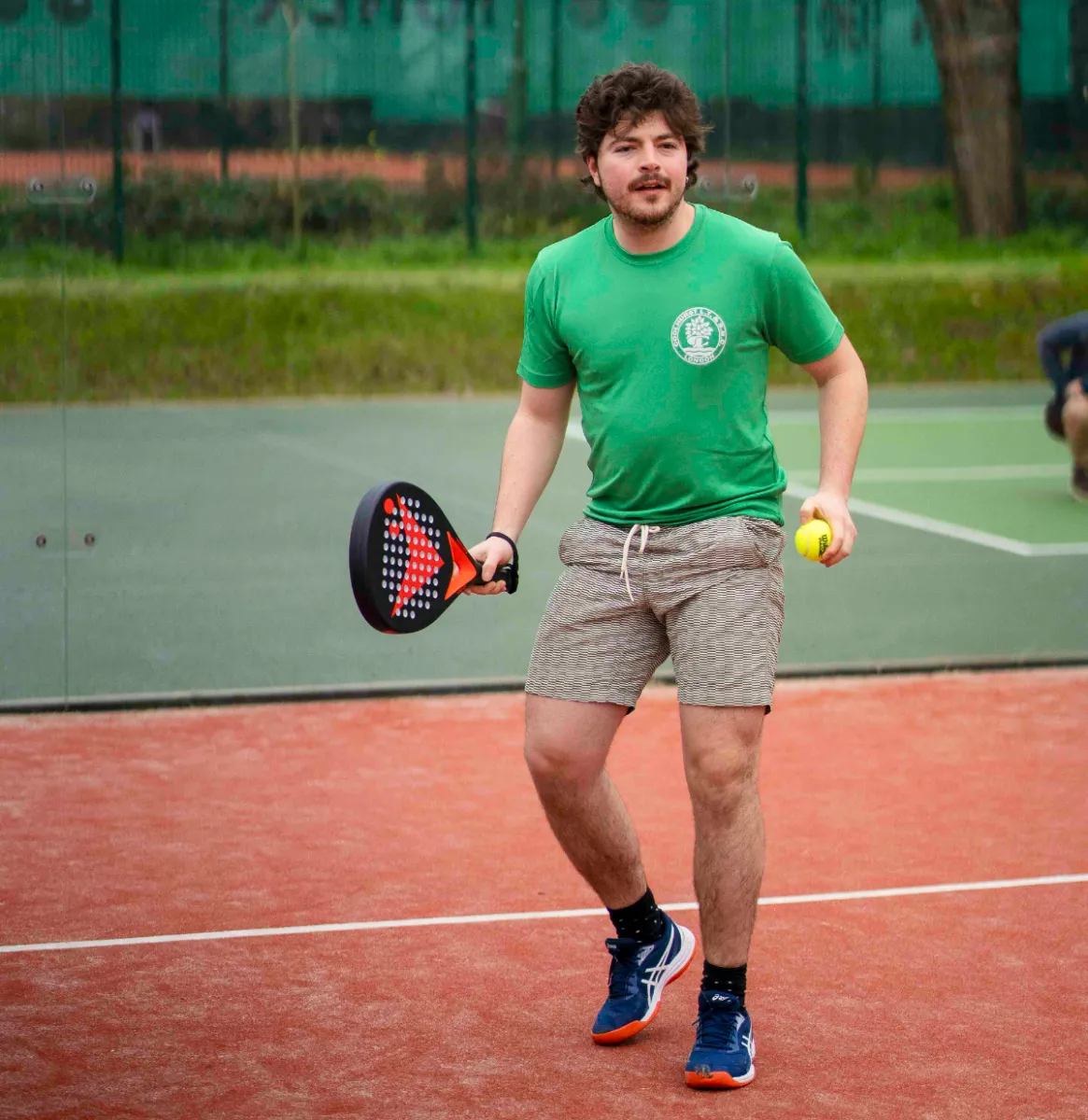 Man preparing to serve with Vadetep padel racket on outdoor court