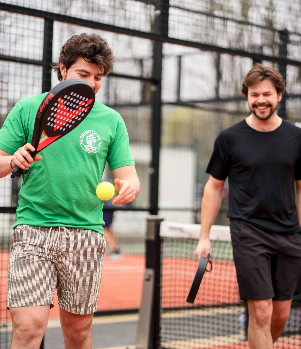 Two men with Vadetep padel rackets between points on court
